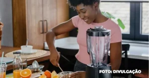 Copo de suco de laranja fresco ao lado de gengibre e cenoura