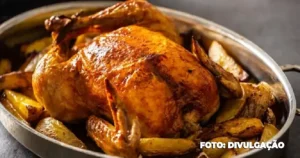 Frango assado com laranja acompanhado de batatas douradas, servido em travessa rústica.